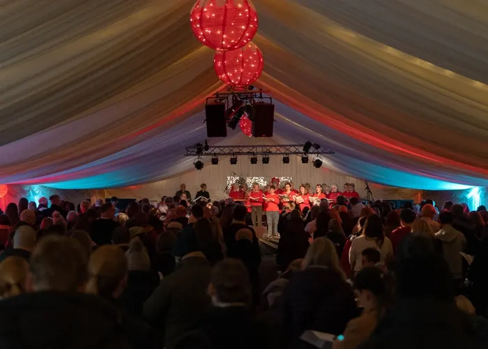 Live choir performance inside the Christmas Lounge marquee